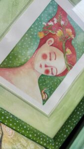 Acquerello con atmosfere sognanti, ispirato alle dame di Botticelli, colori predominanti verde e rosso, cornice personalizzata per l’illustrazione